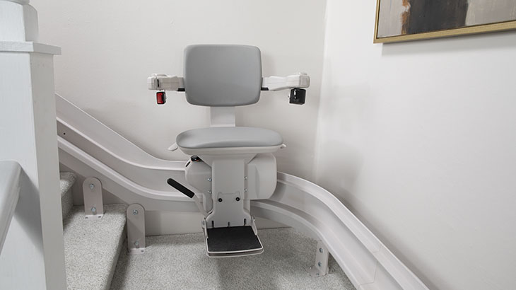 bruno elite curved indoor stair lift at the top of a staircase