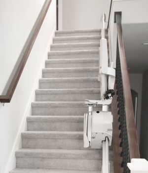 Elan straight indoor stair lift folded at the bottom of the steps