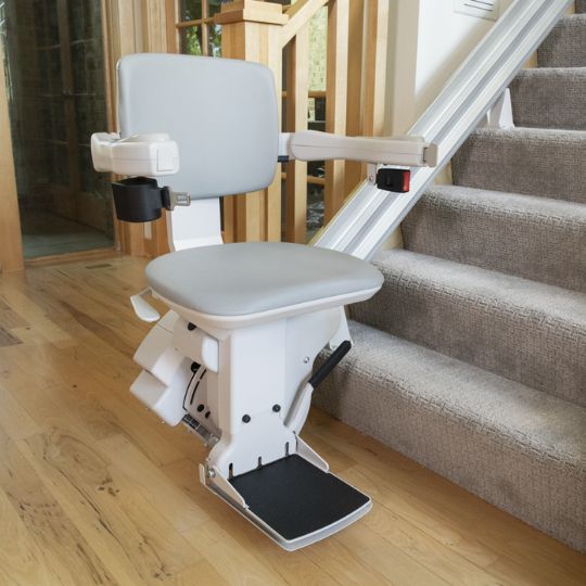 Bruno Elite straight indoor stairlift parked at the bottom of a carpeted staircase